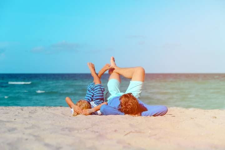 father and son lying on the beach