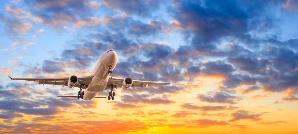 plane flying in the sky at sunset