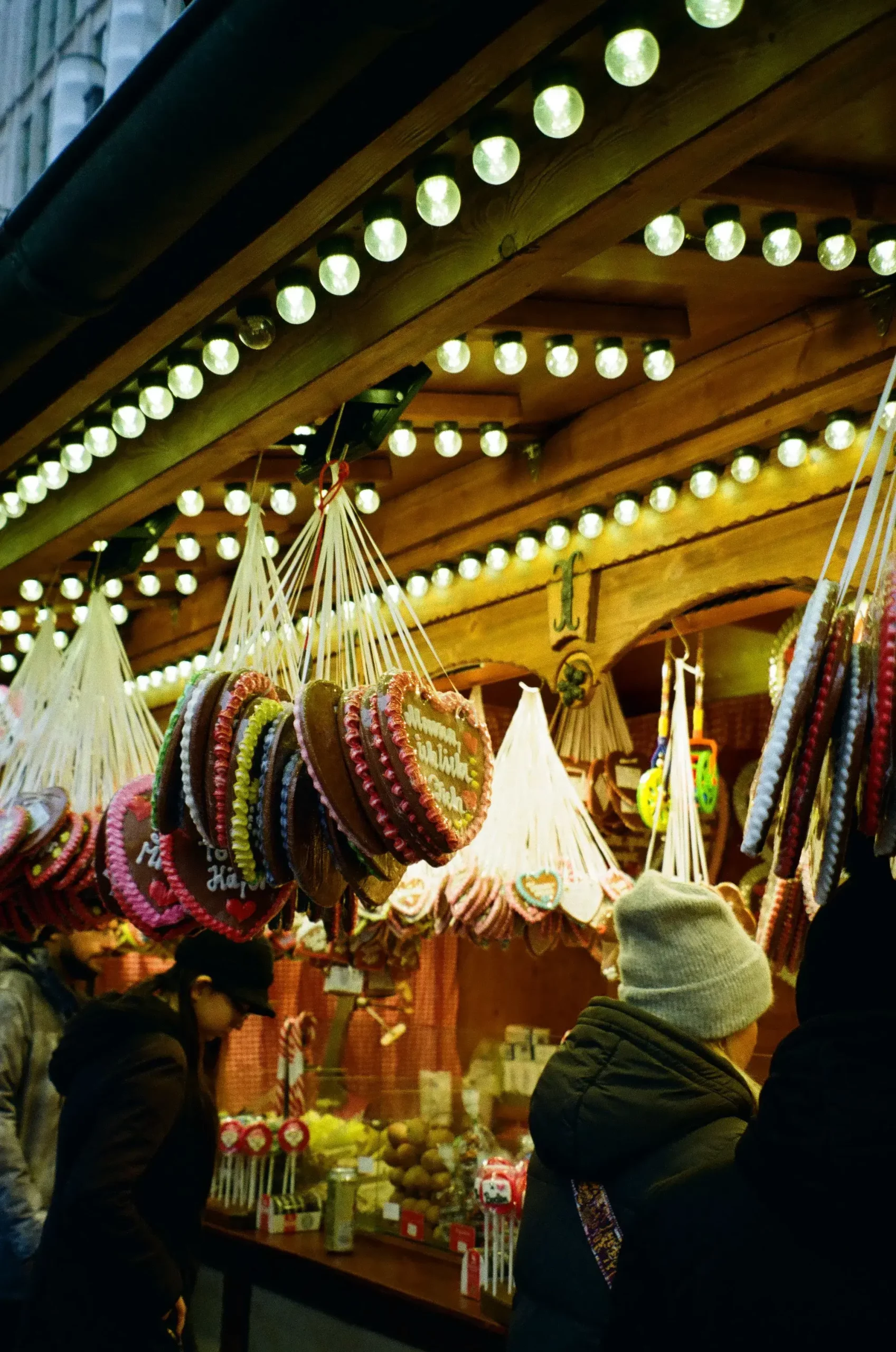 German Christmas market with festive stalls, twinkling lights and shoppers browsing decorations