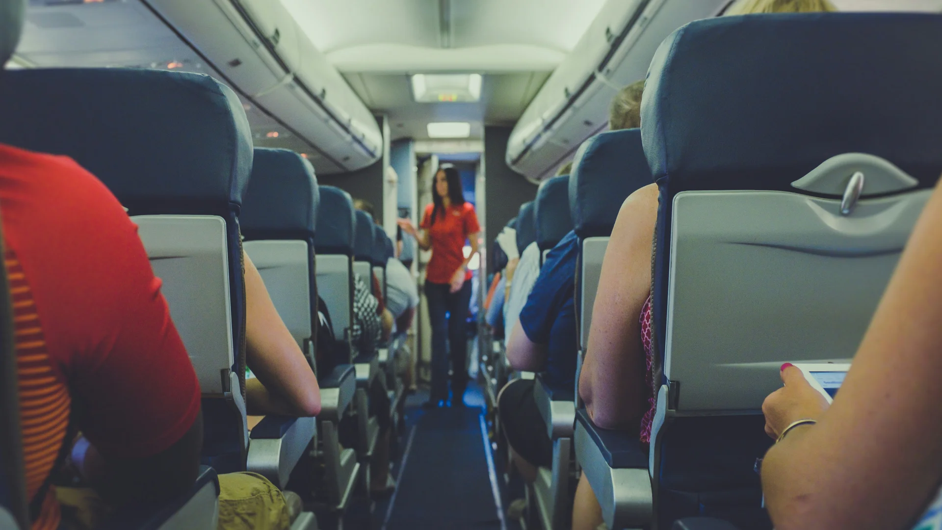 Passenger placing a bag into an overhead locker on an aircraft