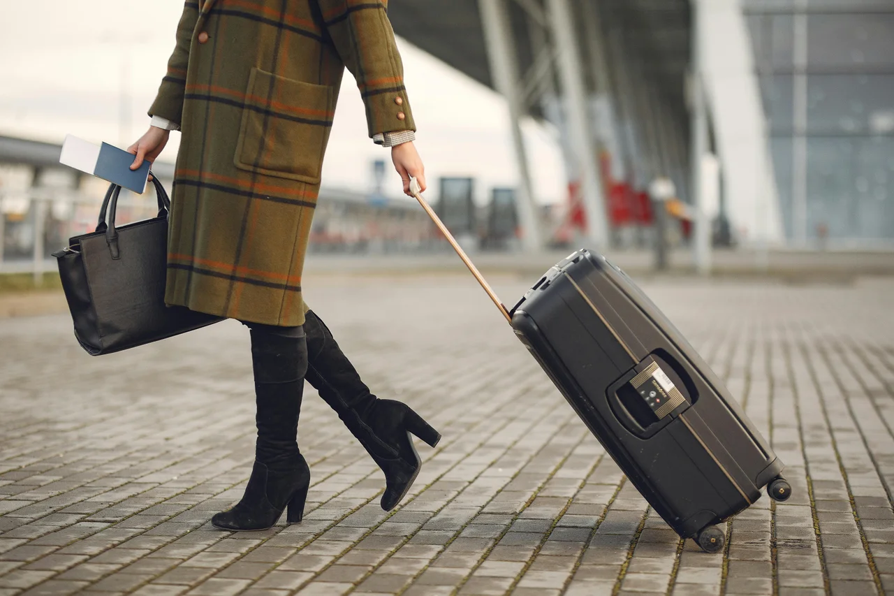 Passenger placing hand luggage in overhead locker on aircraft